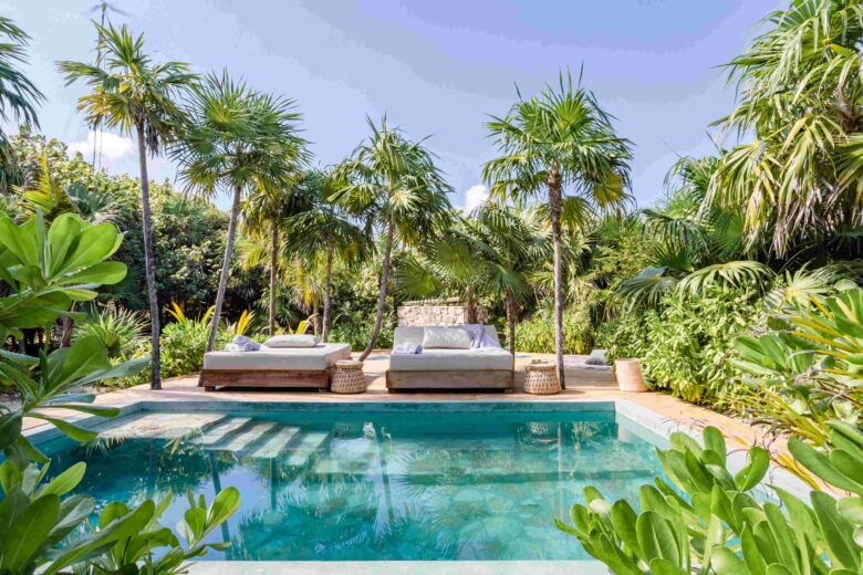 Cenote-style pool with loungers at ANANA Casa Kaab Kaan luxury villa in Tulum, surrounded by lush tropical vegetation.