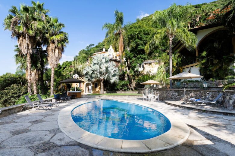 Private pool surrounded by palm trees and mountain views in Ajijic vacation rental